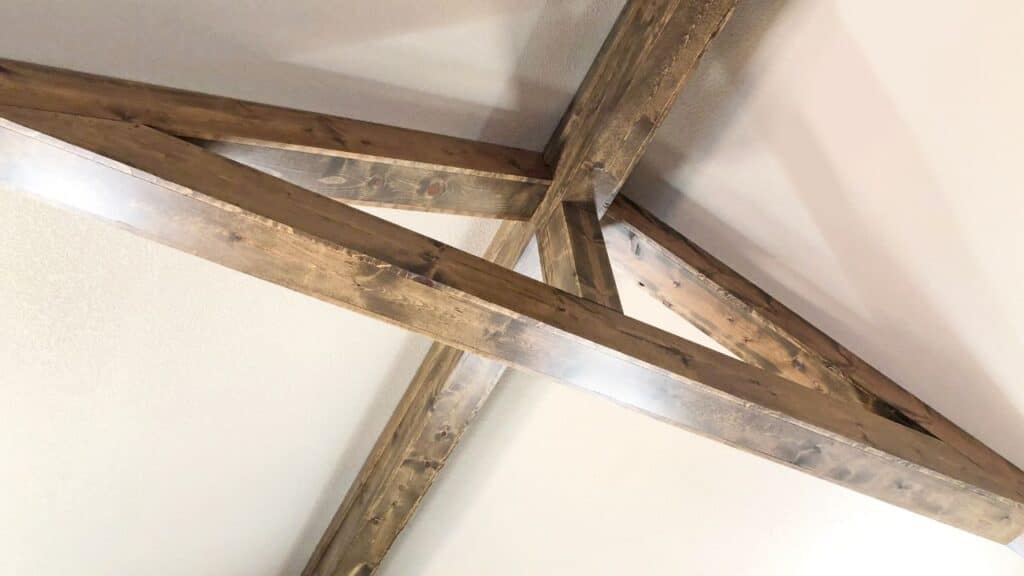 Rustic wooden ceiling beams add character and warmth to a neutral room, a perfect way to elevate your home decor.