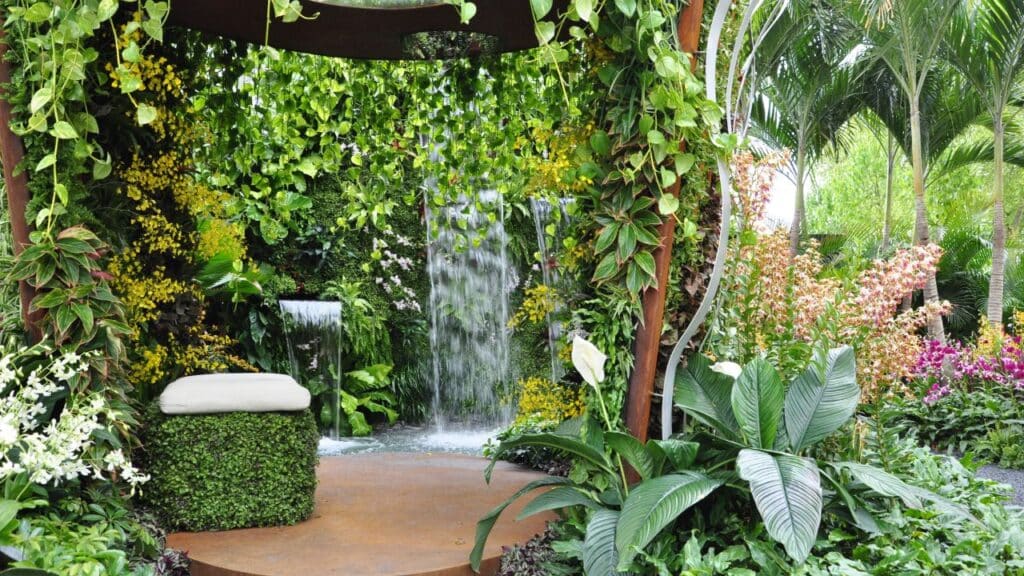 A lush garden oasis featuring cascading waterfalls, vibrant tropical plants, and a serene seating area, creating the ultimate relaxing backyard retreat.