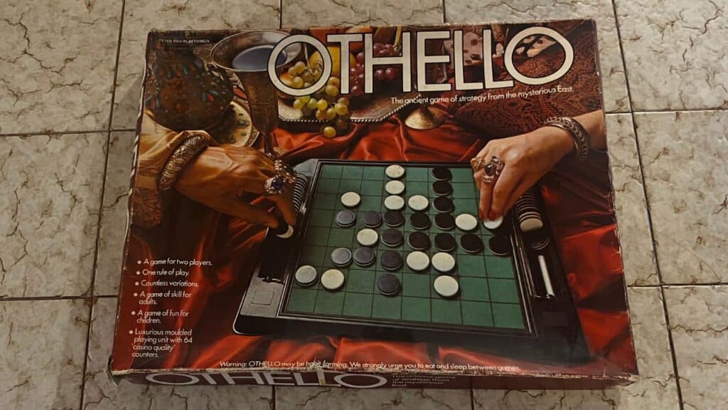 A boxed Othello board game features a green grid with black and white discs mid-game, surrounded by ornate accessories. Known for its strategic play, it was a hit among childhood toys from the 70s.