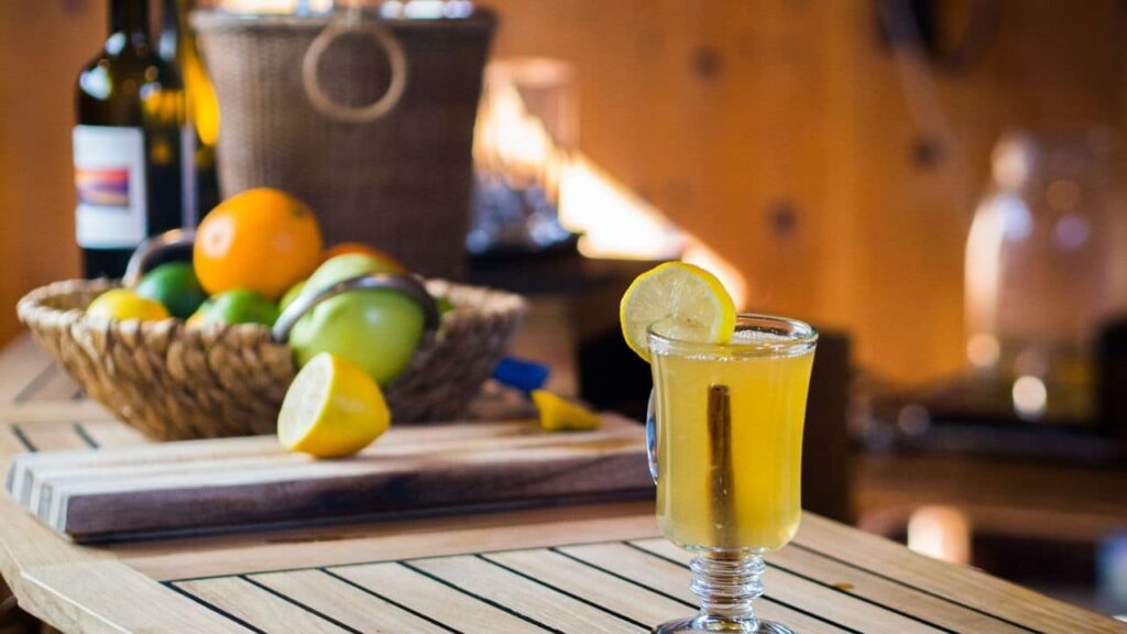 A hot toddy on a wooden bench with lemons and oranges