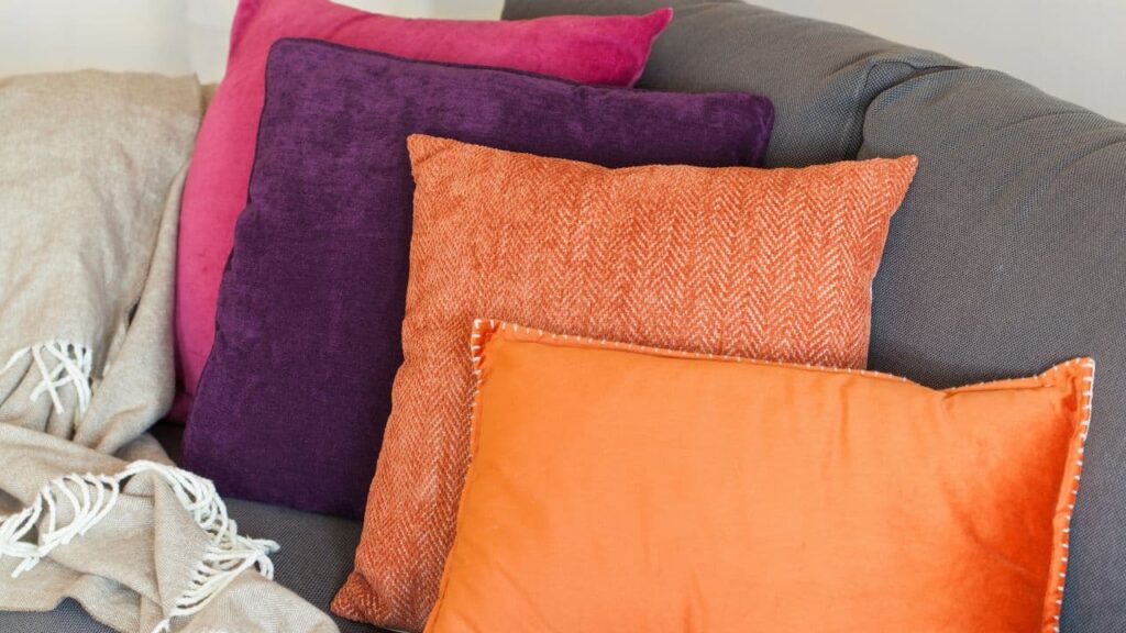 Orange and plum cushions on a sofa