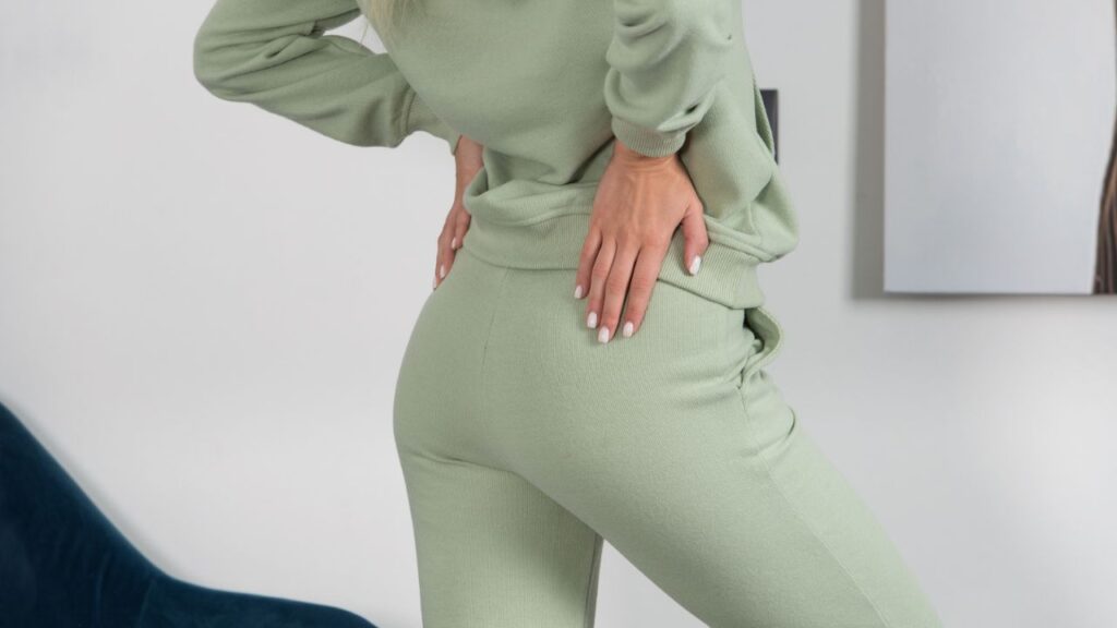Person in a light green matching tracksuit posing indoors, showing how tight loungewear can become a fashion faux pas in certain settings.