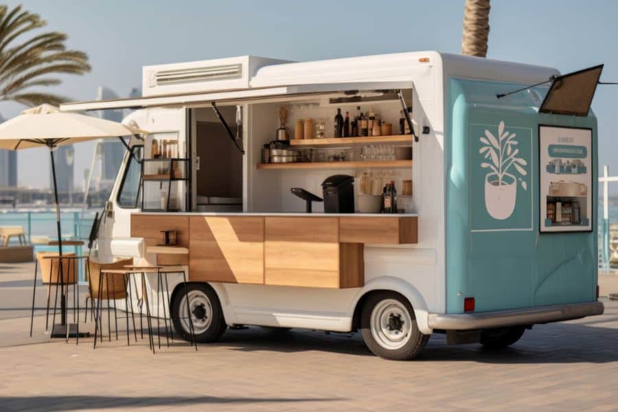 A modern mobile coffee truck parked near a waterfront with bar stools and an open counter, ideal for showcasing a retiree-friendly job running a part-time food or beverage business.