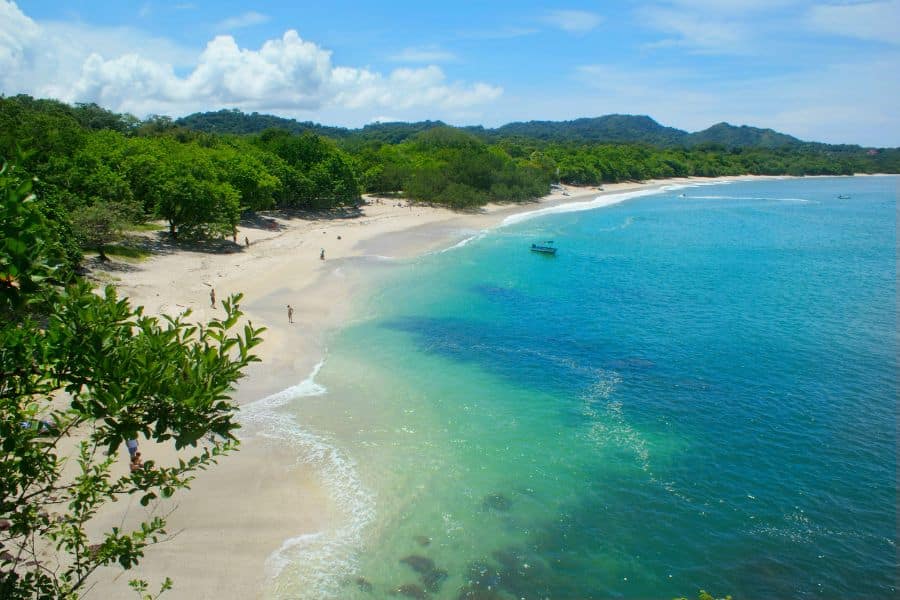 A tropical beach in Costa Rica with turquoise water, white sand, and lush greenery. Costa Rica is a favorite among countries that welcome Americans for its nature and relaxed lifestyle.