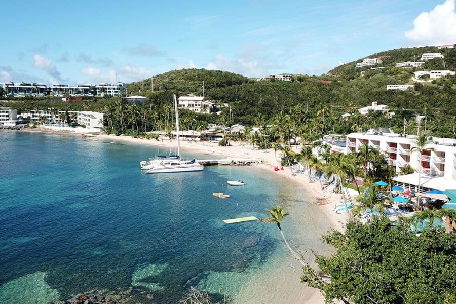 Aerial view of Bolongo Bay in the US Virgin Islands shows a white sand beach, clear turquoise water, and nearby resorts, perfect for relaxing at All-Inclusive Resorts in the US.