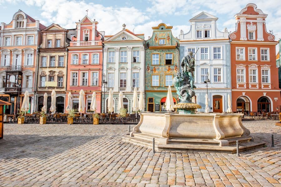 Cobbled square lined with colorful historic townhouses and a central fountain in Poznań’s Old Town, Poland, an affordable European city with vibrant culture and charm.