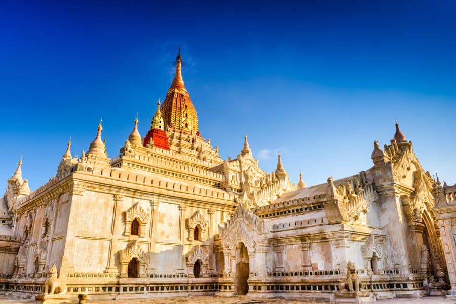 The golden spires of Ananda Temple glow under a vibrant blue sky in Bagan, Myanmar. Historic temples like this make Bagan a must-see on any list of Bucket List Destinations to Visit.