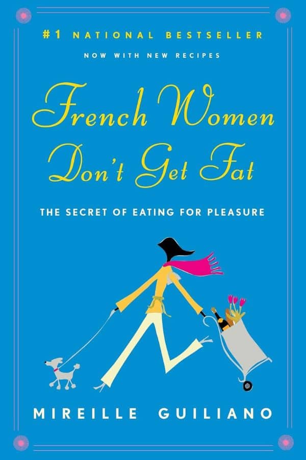 Cover of the book French Women Don’t Get Fat by Mireille Guiliano, featuring a stylized illustration of a chic woman walking a small dog while pulling a grocery cart filled with flowers, bread, and wine. The subtitle reads "The Secret of Eating for Pleasure" and highlights the theme of balanced indulgence.