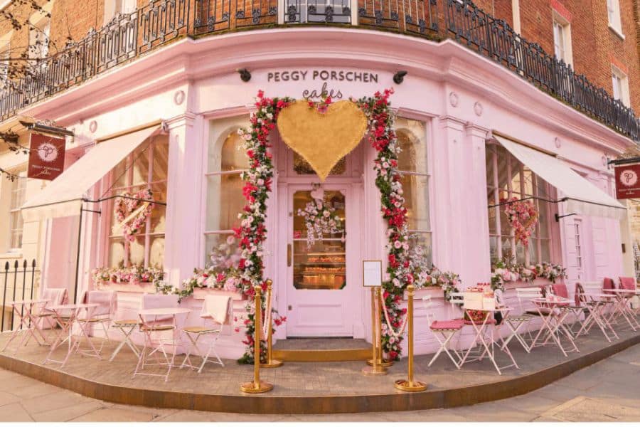 The exterior of Peggy Porschen’s café in London is painted pastel pink and adorned with floral garlands and heart-shaped décor. While more modern, it’s celebrated among Beautiful and Historic Cafés in Europe for its charming atmosphere.