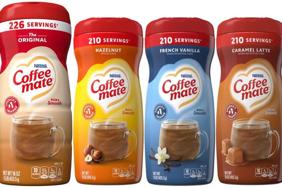 Four containers of flavored coffee creamer including Original, Hazelnut, French Vanilla, and Caramel Latte displayed side by side. These processed creamers are examples of Breakfast Staples Triggering Inflammation because of added sugars and artificial ingredients.