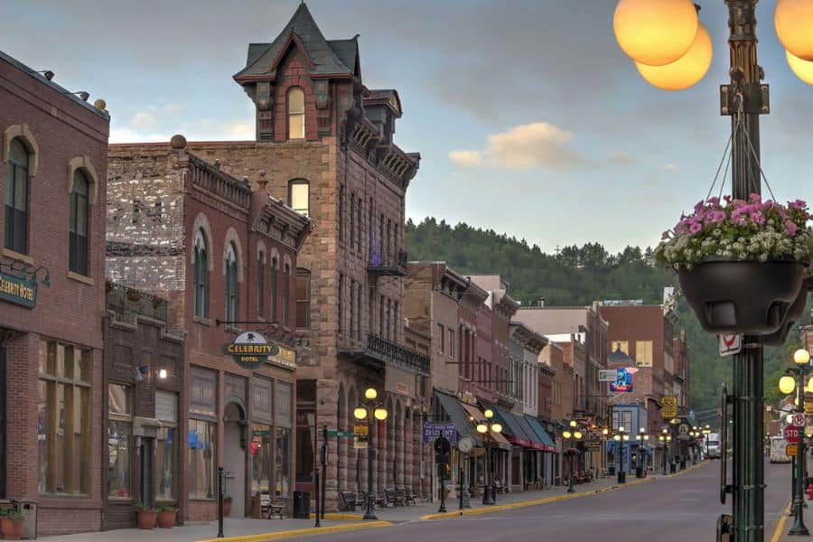 Brick lined main street with ornate nineteenth century buildings glowing under evening lights in historic American towns.