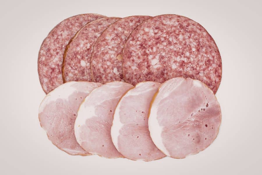 Slices of salami and ham arranged in a row highlighting processed meats as Foods Aging Your Brain.