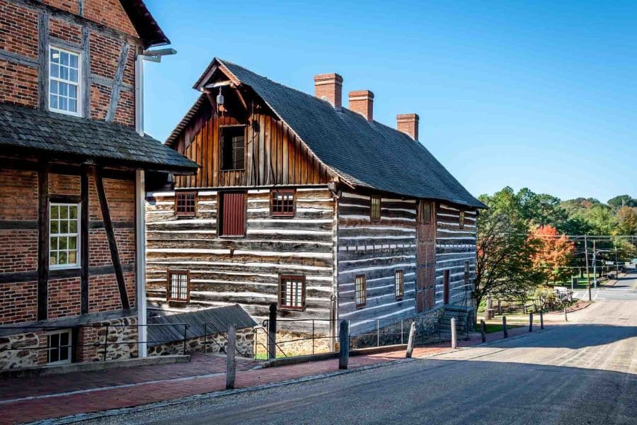 Restored log and brick building on a quiet street showcasing early frontier architecture in historic American towns.