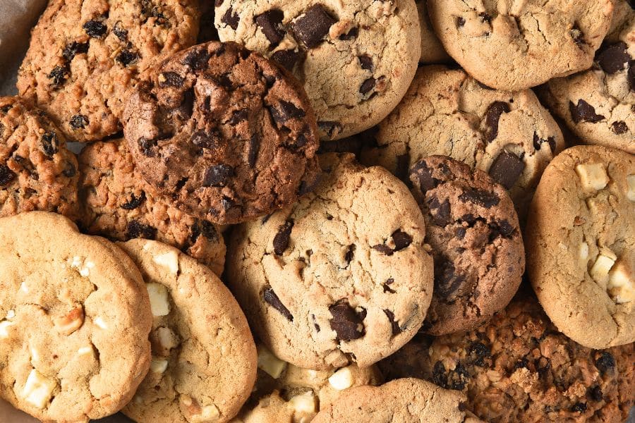 Pile of assorted cookies including chocolate chip and oatmeal varieties emphasizing sugary snacks as Foods Aging Your Brain.