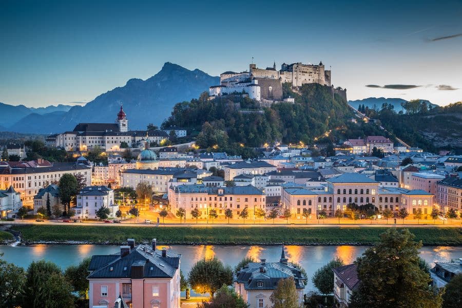 Salzburg’s pastel-colored buildings and winding streets stretch below the hilltop fortress, with mountains silhouetted in the background. This Austrian city’s compact charm and scenic views make it one of the best walkable cities in Europe.