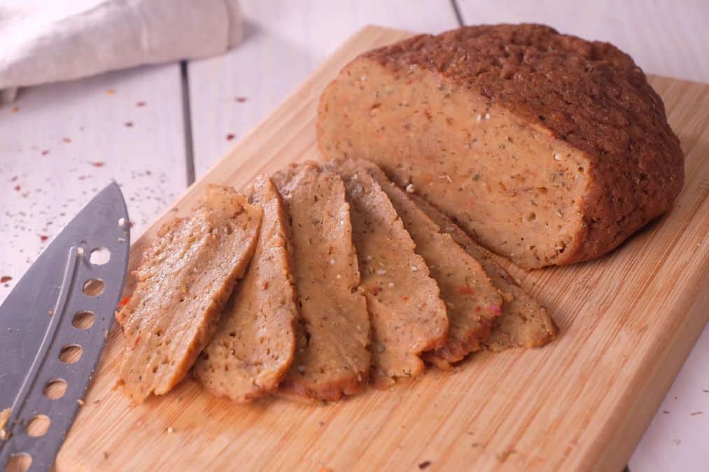 Sliced plant based meat loaf on a cutting board offering hearty plant foods that build muscle.