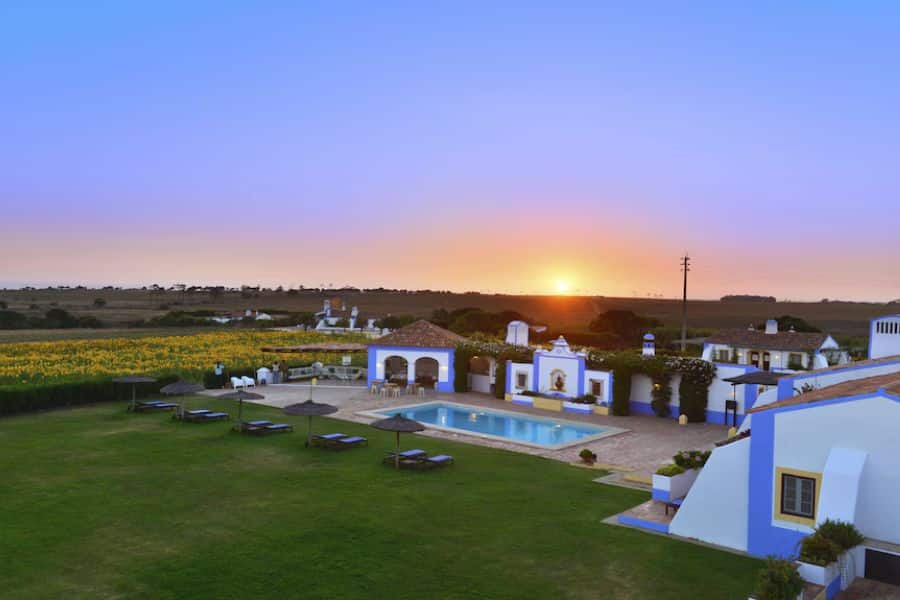 Countryside estate with whitewashed buildings and a pool at sunset set in rural landscapes near European National Parks.