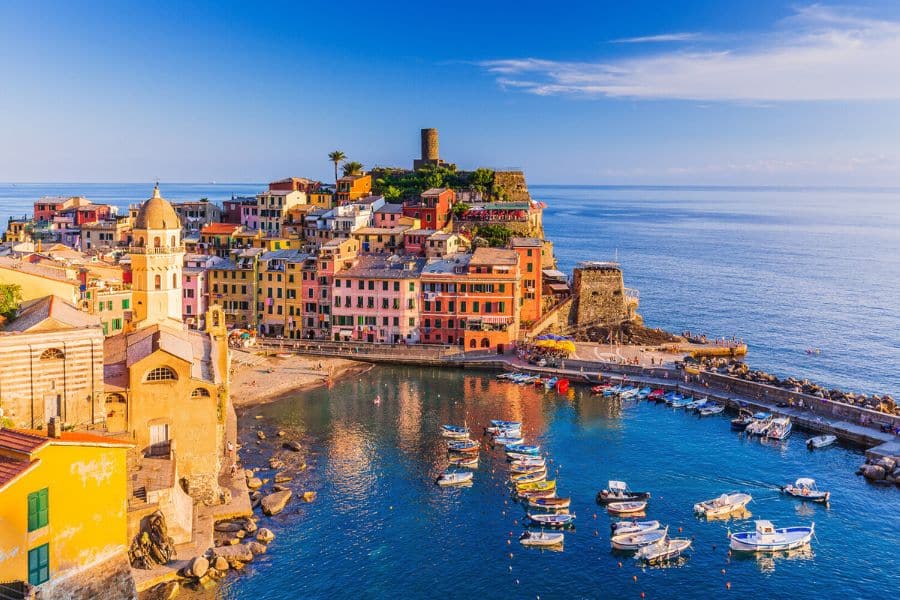 Vibrant harbor lined with pastel buildings and small boats along the Ligurian coast highlighting beautiful villages in Italy.