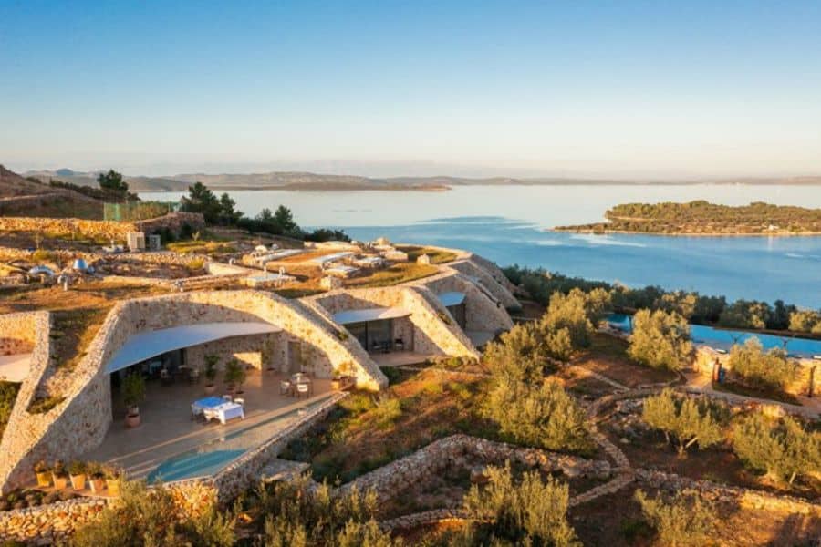 Contemporary stone villa built into a hillside with expansive sea views near European National Parks.