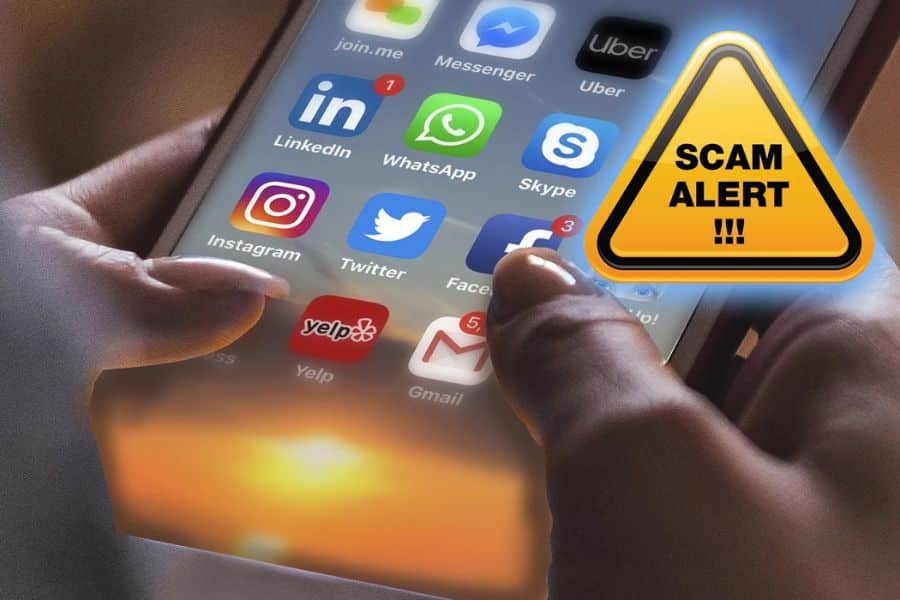 Close up of hands using a smartphone with social media apps on screen next to a yellow warning sign that reads "SCAM ALERT !!!" This graphic illustrates financial scams that can spread through messaging apps and social platforms.