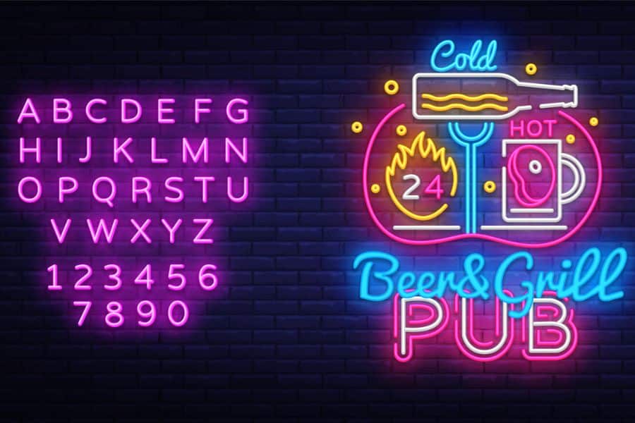 Pink and blue neon signs glow on a dark brick wall with letters numbers and a pub graphic. The signs read "ABCDEFGHIJKLMNOPQRSTUVWXYZ" "123456" "7890" "Cold" "HOT" "24" and "Beer and Grill PUB".
