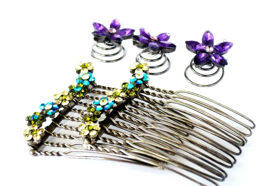 Decorative hair combs and purple flower hair spirals are arranged on a white background. The jeweled accessories could be handmade items sold as a simple side hustle.