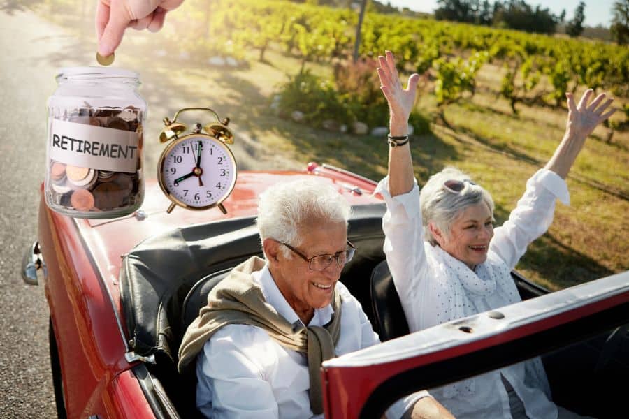 Retired couple smiles while driving in a red convertible through the countryside as a jar labeled “RETIREMENT” fills with coins beside an alarm clock. The image represents financial freedom and lifestyle goals connected to following a retirement rule for long term savings.