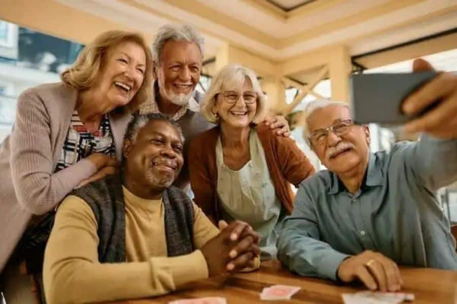 A group of older people huddled around for a selfie