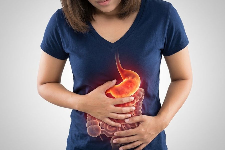 A woman in a blue T-Shirt holding her stomach with an outline of intestines